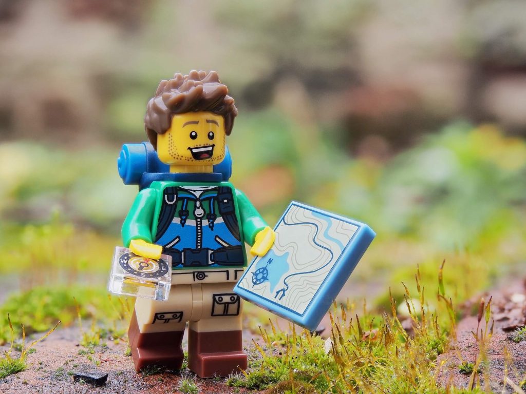 An image of a joyful Lego hiker, equipped with hiking gear and a big smile on their face, capturing the spirit of adventure and outdoor exploration.