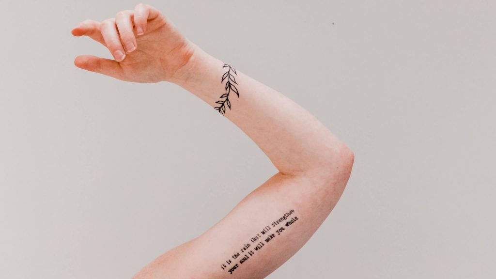 A tattoo featuring various styles of lettering, including names, quotes, or meaningful words.